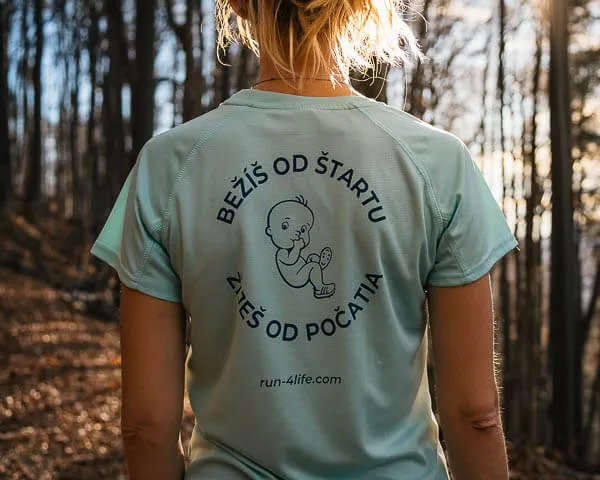 a woman in a blue shirt is walking through the woods